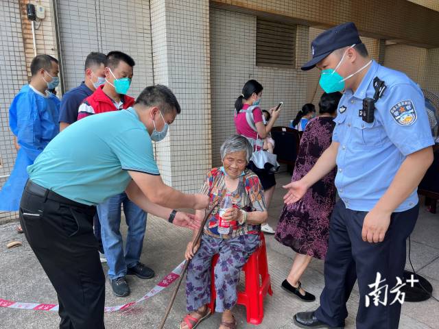 連州市委常委、副市長、九陂鎮(zhèn)黨委書記綦鴻偉在核酸檢測現(xiàn)場協(xié)助老人參加核酸檢測，為老人做好防暑措施。